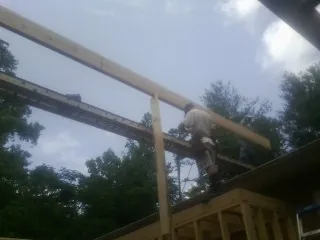 Carpenter setting a ridge beam over a new addition frame — Ice Dam Removal by Roofing Brothers in Tampico