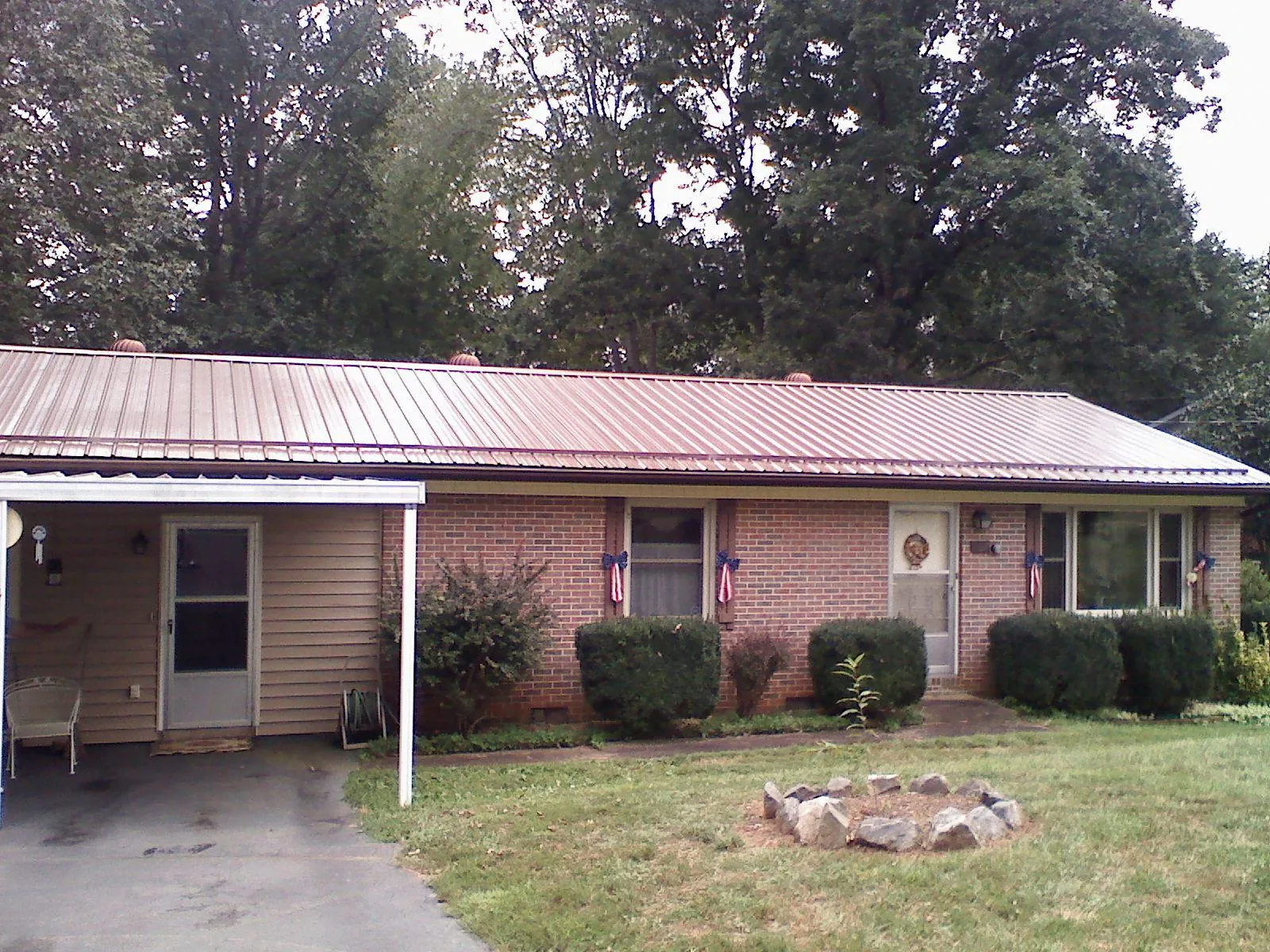 Bronze metal roof and carport on a brick ranch home — Roof Repair work by our crew in Tampico
